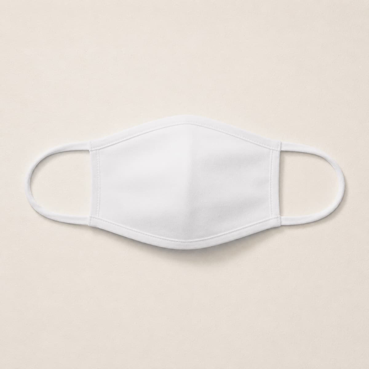 Fabric Face Cover, an unprinted 100% polyester, two-layer; ear loops 100% polyester elastic blank photographed flat on almond paper.